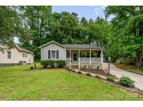 Charming single-story home features a welcoming front porch, well-maintained lawn, and beautiful landscaping at 107 Oakland Rd, Belmont, NC 28012