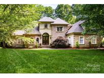 Charming brick home boasts mature landscaping and a meticulously manicured lawn at 122 Sleepy Cove Trl, Mooresville, NC 28117