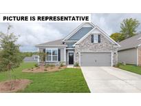 Charming single-Gathering home featuring stone accents, a two-car garage, and a well-manicured lawn at 125 Noah Ln, Troutman, NC 28166