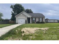Charming single-story home with attached garage and well-maintained lawn with some hay spread out on the front yard at 1381 Steven Dr, Salisbury, NC 28147