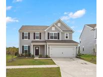 Charming two-story home with grey siding, black shutters, attached two car garage, and well-manicured lawn at 1433 Harleston St, Indian Trail, NC 28079