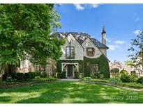 Charming ivy-covered Tudor-style home with stone accents and manicured front lawn at 1550 Queens W Rd, Charlotte, NC 28207