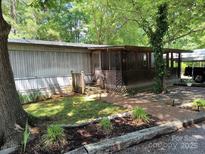 Charming mobile home with a welcoming screened-in porch and well-maintained landscaping at 189 6Th Ave, New London, NC 28127