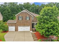 Charming brick home with a well-manicured front yard and attached three-car garage at 1919 Madeira Cir, Waxhaw, NC 28173