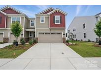 Two-story home featuring a two-car garage, stone accents, and well-maintained landscaping at 2021 Vinyasa Ln # Sts-41, Charlotte, NC 28215