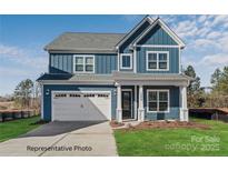 Charming two-story home with blue siding, a white garage door, and well-maintained lawn at 20392 Queens St, Cornelius, NC 28031