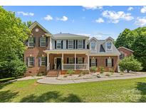 Charming two-story brick home with a welcoming front porch and well-manicured lawn at 220 Glenville Dr, Fort Mill, SC 29715