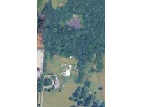 An aerial view of a sprawling property featuring lush greenery, a serene pond, and multiple buildings at 269 Johnson Dairy Rd, Mooresville, NC 28115