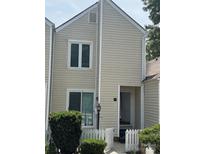Traditional two-story townhouse featuring neutral siding, white trim, and charming picket fence at 303 Eastwood Dr, Salisbury, NC 28146