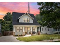 Charming two-story home with a manicured lawn, inviting front porch, and black frame windows at 304 Keswick Ave, Charlotte, NC 28206