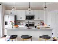 Bright, modern kitchen featuring white cabinetry, stainless steel appliances, and a large island with seating at 4110 Lattistep Ln, Charlotte, NC 28269