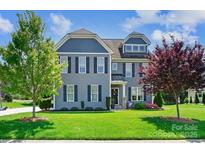 Beautiful two-story home with lush green lawn, attractive landscaping and trees at 4151 Green Park Ct, Harrisburg, NC 28075