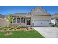 Charming single-story home features a two-car garage, brick accents, and well-manicured lawn under a clear blue sky at 505 York Rd, Troutman, NC 28166