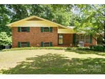 Charming brick home with green shutters and a well-maintained lawn in a peaceful, tree-filled neighborhood at 52 September Ct, Concord, NC 28025