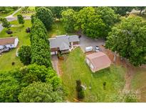 Expansive aerial view of property showing brick home, detached garage, and mature landscaping at 648 Odell School Rd, Concord, NC 28027