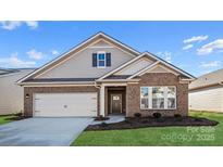 Charming single-story home with brick accents, a two-car garage, and well-maintained landscaping at 674 Georgie St, Troutman, NC 28166