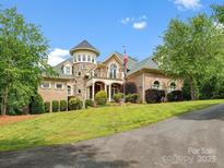 Elegant brick home with a turret, manicured lawn, and a welcoming driveway at 6742 Charlotte Hwy, York, SC 29745