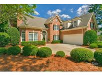 Beautiful two-story brick home with manicured lawn, mature trees and two car garage at 10508 Old Wayside Rd, Charlotte, NC 28277