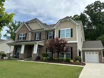 Well-manicured lawn and beautiful brick and siding exterior create a welcoming curb appeal at 10800 Alabaster Dr, Davidson, NC 28036