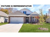 Charming single-story home with brick accents, a two-car garage, and a well-manicured lawn at 119 S Shayna Rd, Troutman, NC 28166