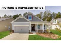Charming one-story home featuring a welcoming front porch, attached garage, and well-maintained landscaping at 121 S Shayna Rd, Troutman, NC 28166