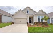 Charming single-story home featuring a two-car garage and manicured front lawn at 128 S Shayna Rd, Troutman, NC 28166