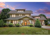Beautiful two-story home with a manicured lawn and charming covered front porch at 14701 Cabarrus Rd, Mint Hill, NC 28227