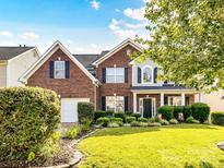 Charming brick two-story home with lush landscaping and manicured lawn at 1564 Trippett Nw St, Concord, NC 28027