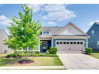 Charming blue two-story home featuring an attached garage, landscaped yard, and a welcoming entrance at 1636 Red Leaf Dr, Fort Mill, SC 29715