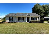Charming single-story home with a well-maintained lawn and beautiful landscaping at 1820 Wendover Dr, Lancaster, SC 29720