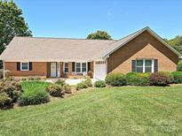 Charming brick home featuring manicured lawn, beautiful landscaping, and an attached two-car garage at 202 Cameron Dr, Kings Mountain, NC 28086