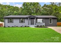 Charming, newly renovated home with a fresh gray exterior, updated windows, and lush green lawn at 316 Fulton St, Kings Mountain, NC 28086
