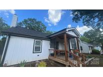 Cozy home featuring a quaint covered porch and a well-maintained, neutral exterior at 319 Leonard Ave, Albemarle, NC 28001