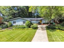 Charming single-story home featuring lush landscaping, manicured lawn and a bright yellow front door at 331 Glen Oaks Rd, Charlotte, NC 28270