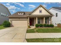 Charming single-story home with a well-manicured lawn, a two-car garage and inviting front porch at 333 Dudley Dr, Fort Mill, SC 29715
