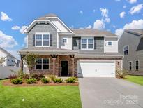 Beautiful two-story home with stone accents, covered porch, and well-manicured lawn at 3615 Slider Ter, Indian Land, SC 29720