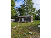Rustic cabin-style home with weathered wood exterior and a small front porch, surrounded by trees at 5040 Fairview Church Rd, Lincolnton, NC 28092