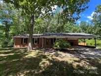 Charming brick home with attached carport nestled among mature trees at 511 Evelyn Ave, Kannapolis, NC 28083