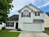 Charming two-story home featuring white siding, red shutters, and an attached two-car garage at 710 Woodington Ln, Charlotte, NC 28214