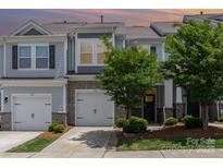 Charming townhome with stone accents, attached garages, and well-maintained landscaping at 724 Little Bluestem Dr, Lake Wylie, SC 29710
