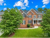 Beautiful two-story brick home with well-manicured lawn and mature trees at 10024 Hazelview Dr, Charlotte, NC 28277