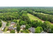 A stunning aerial view of the neighborhood with its mature trees and lush greenery, with golf course in the distance at 10317 Clubhouse View Ln, Mint Hill, NC 28227