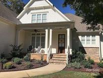 Charming home entrance featuring brick stairs, stone accents, and a covered porch with seating at 104 Bunker Way # 1001, Mooresville, NC 28117