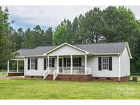 Charming single-story home with a inviting front porch and well-maintained lawn and mature landscaping at 1274 Carpenter Springs Dr, Dallas, NC 28034