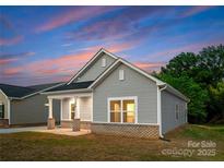 Charming single-story home with gray siding, brick foundation, and a covered front porch at sunset at 1623 Martin Ave, Gastonia, NC 28052