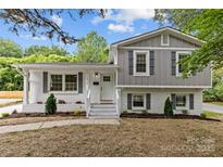 Charming two-story home with painted brick and grey accents, complemented by a landscaped front yard at 1814 Brookdale Ave, Charlotte, NC 28210