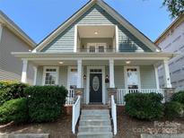 Charming two-story home featuring a welcoming front porch with stone accents and a second-story balcony at 4135 Twenty Grand Dr, Indian Trail, NC 28079
