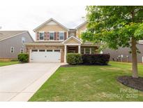 Charming two-story home with brick and siding, attached two-car garage, and well-manicured lawn at 4935 Norman Park Pl, Clover, SC 29710
