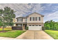 Charming two-story home featuring stone accents, a well-manicured lawn, and an attached two-car garage at 5011 Blue Stream Ln, Indian Trail, NC 28079