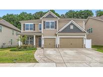 Two-story home with a two-car garage, neutral siding, stone accents, and a well-manicured front yard at 5957 Redwood Pine Rd, Concord, NC 28027